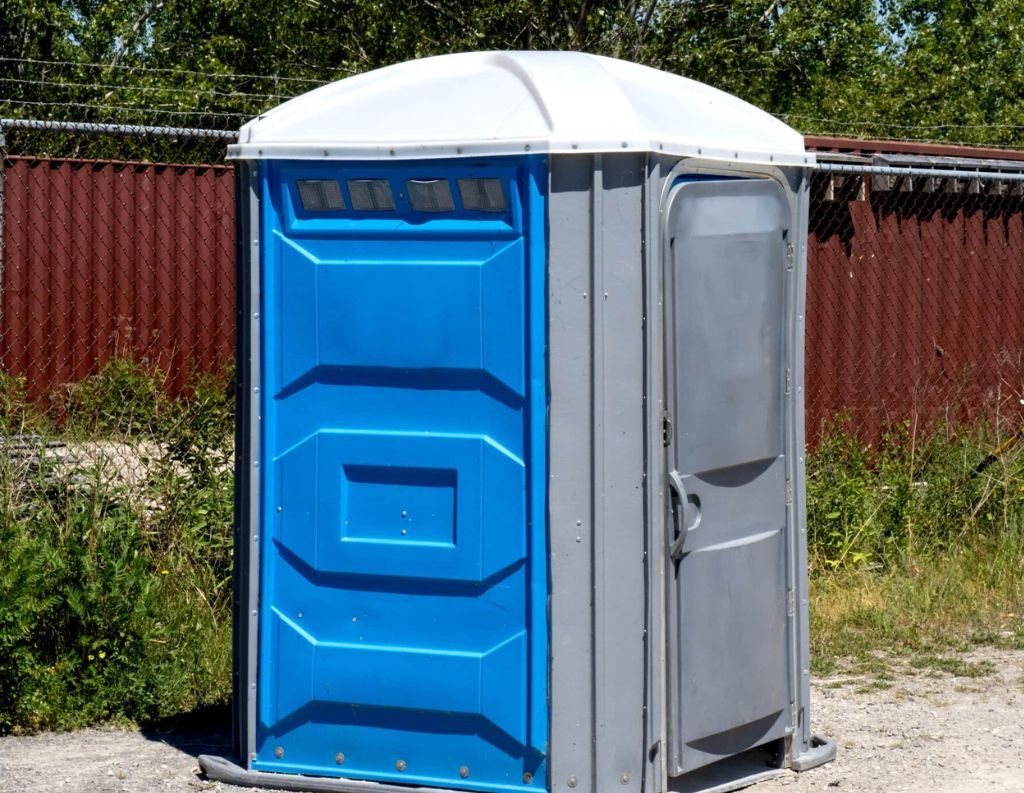 A portable toilet placed on a job site by Prime Porta Potty Rental Houston LLC